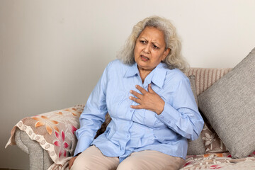 Portrait of indian elderly woman having heart attack at home. old age, health problem and people...