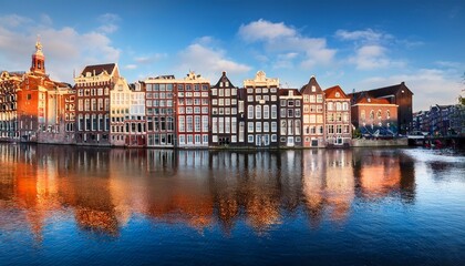 Naklejka premium old houses of amsterdam the houses stand in the water and have a beautiful reflection touristic district damrak these houses are famous all over the world amsterdam holland europe