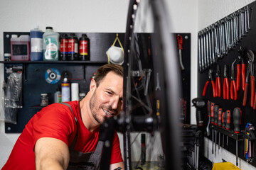 Professional experienced bicycle serviceman fixing broken bike and balancing wheel.