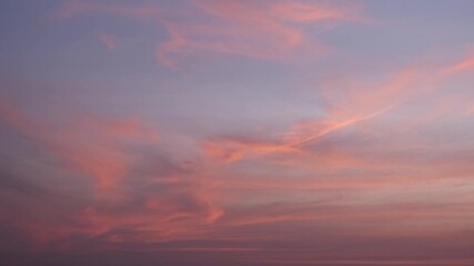 A vibrant sunset sky timelapse with swirling fiery orange and pink clouds contrasted against a fading purple backdrop, evoking a dramatic and captivating close to the day’s light. Time-lapse.
- Powered by Adobe