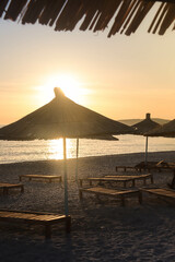 Beach umbrellas at sunset &ndash; relaxing summer scene with silhouettes of umbrellas against a colorful sky. Perfect for travel, vacation, and leisure concepts.