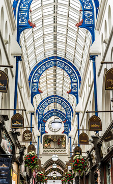 View of Thornton's Arcade, a Victorian shopping arcade opened in 1878, with glass roof, gothic arches and clock with characters from Ivanhoe, in Leeds city centre, England, United Kingdom