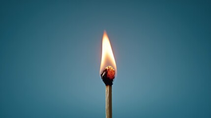 Burning match isolated on teal background