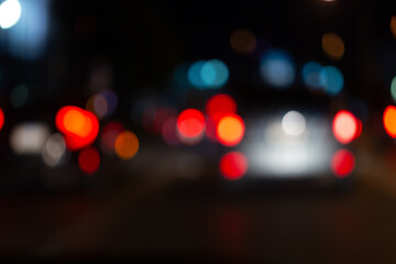 Blurred night traffic scene with glowing car lights and bokeh street lamps, creating a dreamy urban...
