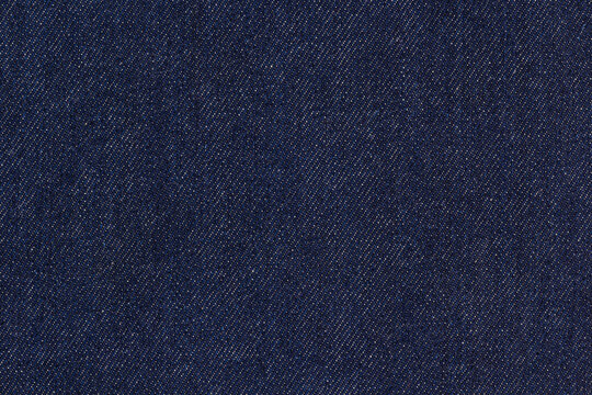 Dark blue denim fabric with detailed weave texture, classic textile material for fashion and design