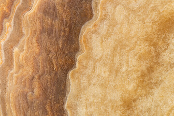  Close-up of beige and brown marble texture with natural flowing pattern, ideal for backgrounds,...
