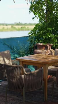 Wooden table and chair on a wooden terrace with a view of the river.
Interior in a private house and exquisite wooden furniture