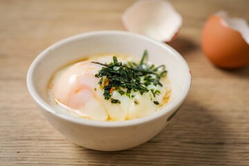 soft boiled egg, onsen egg in white bowl on wooden background