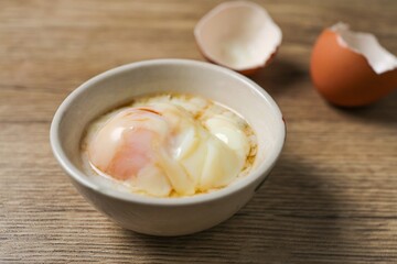 soft boiled egg, onsen egg in white bowl on wooden background