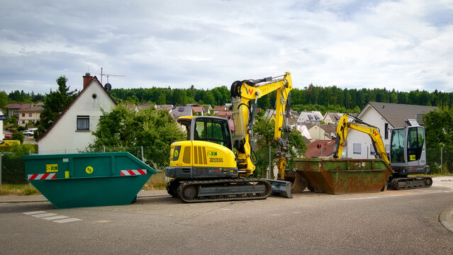 Zwei kleine Bagger der Marke Wacker Neuson, Modelle ET 90 und ET 35 und zwei Container, abgestellt am Strassenrand in einem Wohngebiet in Pforzheim Huchenfeld