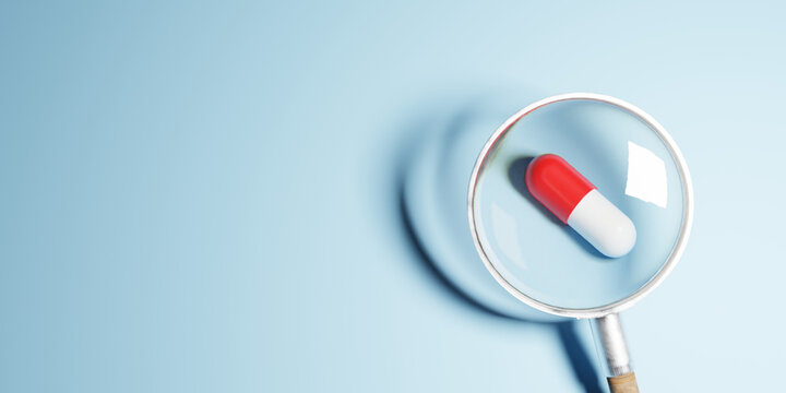 Magnifying glass looking at red pill symbol. Positive thinking mindset or healthcare insurance symbol concept. Business for profit, benefit, development and growth concepts, copy space. 