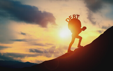 Silhouette of man carrying a stone with word Debt on his back walking up a mountain slope. Concept of debt burden and debt management, financial challenges and effective money management.