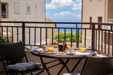 Scenic breakfast on balcony overlooking ocean view with coffee and fresh juices