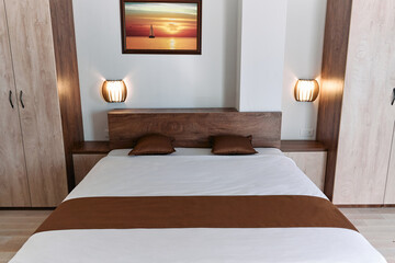 Modern bedroom design with elegant bed and wall art in cozy neutral colors