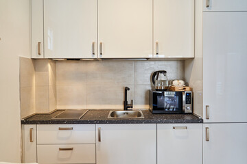 Modern kitchen with white cabinets and black countertop