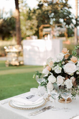 Wedding reception table decorated with elegant floral arrangements, tall glass candlesticks, and soft candlelight. Romantic and festive atmosphere perfect for celebrations and luxury wedding design.