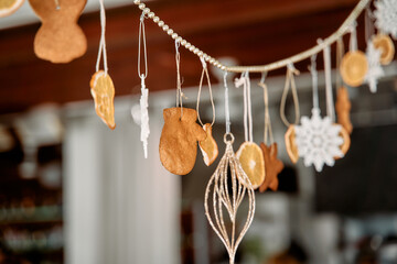 Festive gingerbread decorations and citrus ornaments hanging on a holiday garland