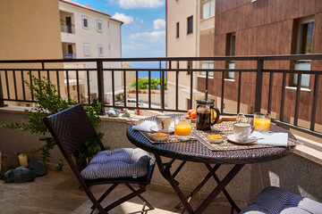 Seaside balcony breakfast with french press and juices on a sunny day