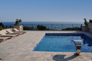 Luxurious oceanfront terrace with infinity pool overlooking serene blue horizon