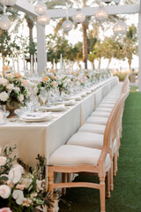 Wedding reception table decorated with elegant floral arrangements, tall glass candlesticks, and soft candlelight. Romantic and festive atmosphere perfect for celebrations and luxury wedding design.