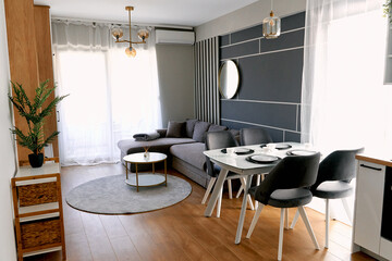 Modern living room with gray sofa, dining set, and contemporary decor