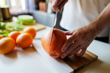 Citrus slicing in a bright kitchen full of fresh ingredients at midday