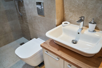 Modern bathroom interior with white sink and toilet featuring sleek fixtures