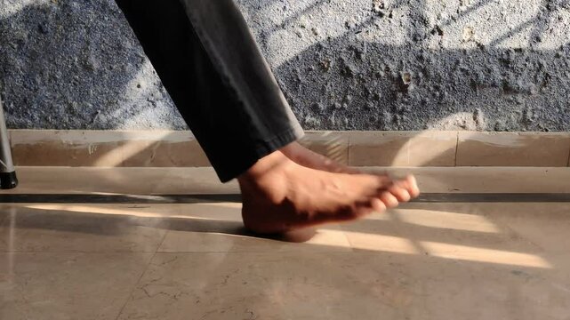Seated Man Shakes Feet Quickly in Front of Moldy Wall Reflecting Unease