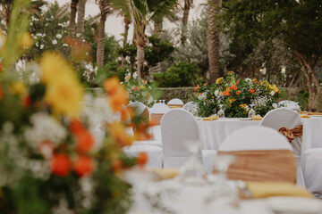 Outdoor wedding table decorated with flowers, elegant tableware, and romantic details, celebration of love and union.