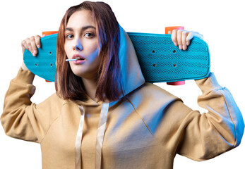 Young beautiful fashionable hipster girl dressed in a hoodie holds a skateboard in her hands on a purple studio background. Eats a lollipop.