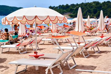 Sandy beach relaxation with sun umbrellas and loungers under a bright summer sky