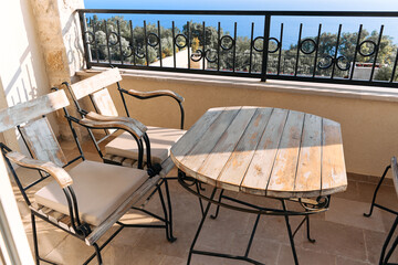 Rustic balcony seating with ocean view and weathered wooden furniture
