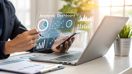 Businessperson analyzing data on laptop and smartphone with charts