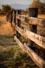 Fototapeta premium Rustic Charm of a Weathered Wooden Fence in Harmonious Landscape Setting