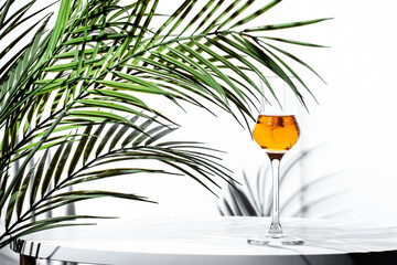 Elegant grappa served in a glass beside tropical palm leaves in a modern setting