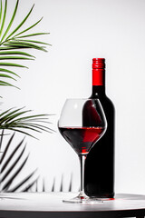 Luxurious non-alcoholic red wine in a crystal glass against an elegant backdrop with green plants creating a sophisticated ambiance