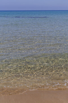 View of the tranquil sea meeting the sandy shore under a clear sky, shimmering with turquoise hues and gentle waves, Dipkarpaz, Northern Cyprus, Cipro.