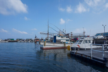 Fototapeta premium Fishing boats moored at a peaceful harbor under a clear summer sky