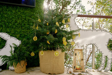 Small christmas tree with gold ornaments and winter decor on balcony terrace