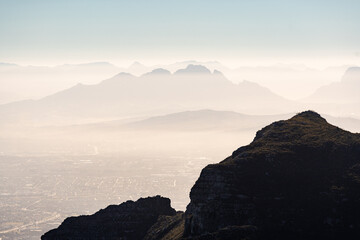 Atmosphärische Berglandschaft mit Dunstschleier und Stadtblick