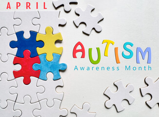 Autism Awareness Month concept with colorful puzzle pieces and text 