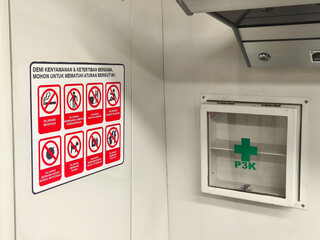 emergency exit sign, A safety and hygiene reminder poster is displayed next to a first aid (P3K) box inside a public facility. The sign lists prohibited activities to ensure cleanliness, order, and co