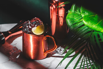 Cold summer alcoholic cocktail drink with gin, beer, lime juice and ice in copper mug