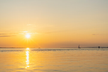 Boat sailing alone on Lake Constance, lonely sailing ship waiting for the sunset in the golden hour, restful peace after a busy day, summer feelings on vacation on the lake