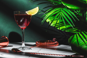 Red alcoholic cocktail drink with whiskey, french brandy, juice, grenadine and lime slice