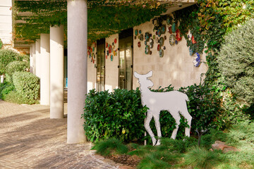 Deer sculpture in lush courtyard with ivy-covered walls and vibrant artwork