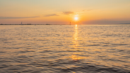 Sailing ship on Lake Constance before sunset, the sun illuminates the lake and conjures up intense colors on the water and the sky, black silhouettes against a bright backlight, holiday cruise