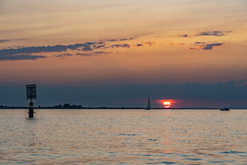 Sunset with sailing ship, boat on Lake Constance, red and orange sunset above the waves on the...
