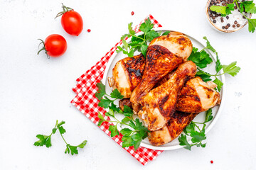 Baked chicken legs or drumsticks, white table background, top view