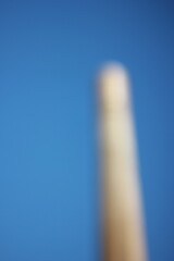 A dreamy view of a brick industrial chimney stack.